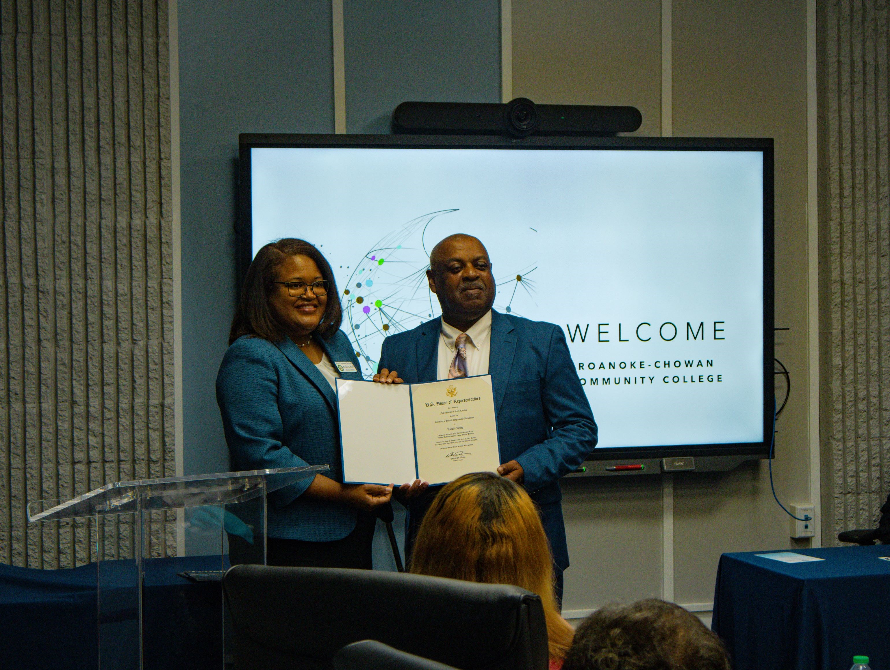 Roanoke-Chowan Community College (R-CCC) formally recognized Ronald J. Gatling, long-serving Chair of the Board of Trustees, during a retirement recognition service held June 24. Pictured is District Director Kimberly Mack (left), representing U.S. Congressman Don Davis (NC-01), who presented Gatling with a certificate of special Congressional recognition.