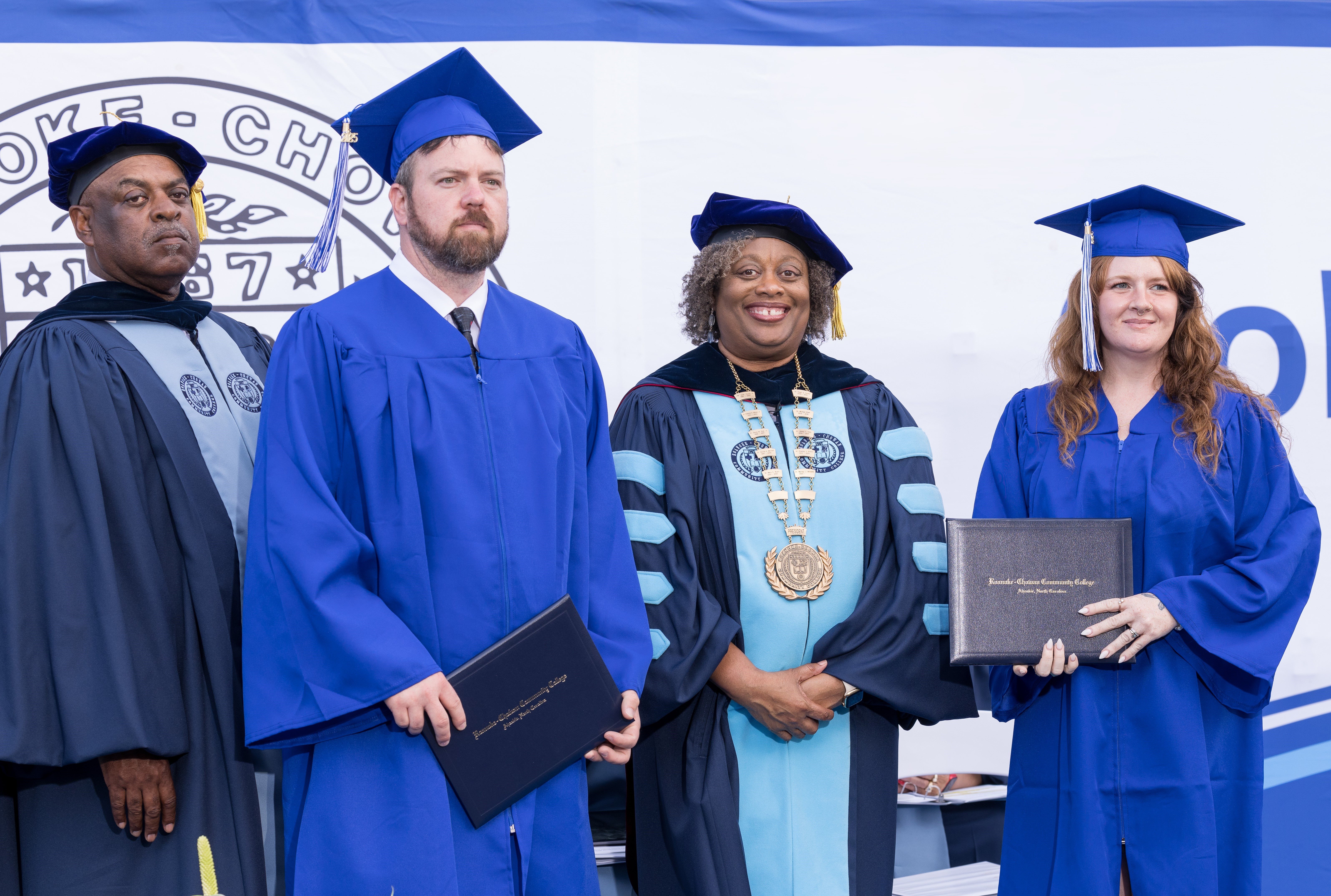 Kirk Holloman, second from left, and Lauren Holloman, right, a husband-and-wife team earned their degrees side by side during Roanoke-Chowan Community College’s 56th commencement ceremony on May 2. Both earned the Associate in Applied Science Emergency Medical Science – Bridging Option. They are pictured with R-CCC Board of Trustees Chair Ronald Gatling, left, and R-CCC President Dr. Murray J. Williams, center.